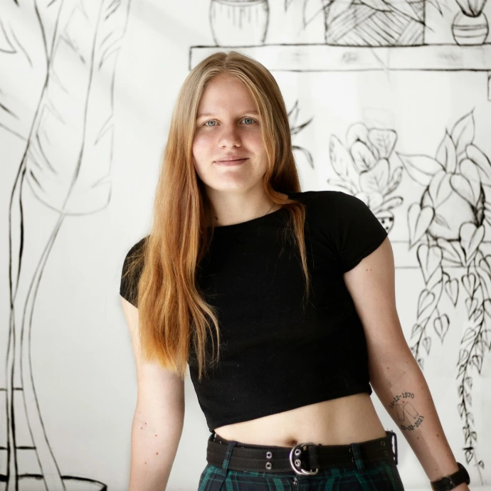 a woman standing in front of a wall with a drawing on it